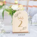 Wooden arched table number sign detail view with floral decor and clear size marks for wedding. - Wedding Table Numbers 1-10