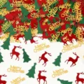 Detailansicht der Weihnachtstischkonfetti, goldener Text, rote Rentiere, grüne Weihnachtsbäume. - Weihnachtsthema / 100 Stück/Packung / bunt