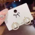 Detail shot of elegant geometric round cat eye earrings with sparkling rhinestone accents. - Round Stud Earrings