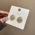Detailaufnahme von exquisiten quadratischen Strass-Perlen-Ohrringen mit S925 Silber-Stiften. - Quadratisch / Gold