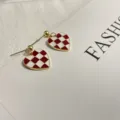 Close-up detail of stylish red and white checkerboard heart earrings with silver needle. - Red & White Checkered Color-Preserving Gold