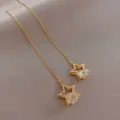 Detailansicht eleganter goldener Stern Ohrfaden, funkelnd mit funkelnden Zirkonia Kristallen. - Weiß