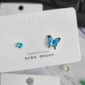 Exquisite asymmetrische blaue Schmetterling und runder Zirkon Ohrstecker Detailansicht. - Blauer Schmetterling