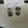 Nahaufnahme Detail silberner Kristallohrringe mit funkelndem quadratischen Stein und Scheibe. - Silber Paillette Graublau