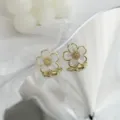 Nahaufnahme Detail von goldenen weißen Blumen Ohrringen mit zarten Blüten im Retro-Stil. - Blumen Stil