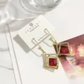 Exquisite geometrische Kristall-Ohrringe mit rosa Stein und elegantem Gold-Finish Detail. - Fuchsia