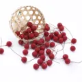 Bacche rosse artificiali in schiuma su steli di filo con cestino intrecciato per decorazioni natalizie. - Rosso