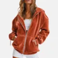 Velour zip-up hoodie detail showcasing soft texture, loose fit, and comfortable front pockets. - S / Orange Red