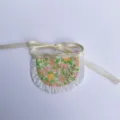 Miniature handmade doll apron accessory, cute floral fabric with white ruffle and ribbon ties. - Yellow Garden Bib