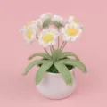 Detail showing a handmade crochet daisy flower pot with white petals on a pink background. - White Daisy (MENGSI) / White