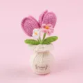 Detaillierte handgehäkelte rosa Tulpe in einer weißen Webvase auf rosa Hintergrund - Rosenrosa