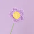 Detailed macro shot of a handmade purple and yellow crochet Afghan flower with stem - Purple