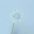Detailed macro view of a handmade crocheted yarn flower with delicate mint green petals - Blue