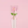 Detailed view of a handmade pink crocheted yarn puff flower in LOVE gift wrap. - Large Puff Flower (Double Leaf) With Bag / Pink