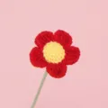 Primo piano di un fiore fatto a mano all'uncinetto rosso e giallo in lana fine - Rosso