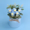 Detailansicht handgefertigter blauer Häkelblumen in einem Topf mit Juteschleife - Blau