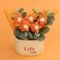 Detailed macro view of hand-knitted orange puff flowers in a cream-colored decorative pot - Puff Flower Potted Plant / Orange