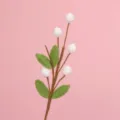 Close-up of a handcrafted crochet autumn fruit branch with white berries and green leaves. - White