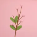 Detailed view of exquisite handmade pink crochet fruit branch with green leaves decoration - Pink