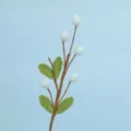 Macro view of handmade crochet flower branch with blue berries and green leaves - Blue