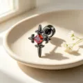 Close-up detail of a gothic black cross earring with a brilliant red square zircon stone - Black Red (Single)