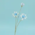 Makroansicht der blauen gehäkelten Gänseblümchenblüte mit detaillierter Stricktextur - Blau