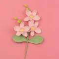 Detailansicht einer handgehäkelten rosa Phalaenopsis-Orchidee auf einem rosa Hintergrund - Rosa