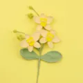 Makro-Detail von handgehäkelten gelben Phalaenopsis-Orchideenblüten mit grünen Blättern - Gelb