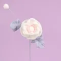 Detailed macro view of handmade white crochet Ranunculus flower with lavender leaves - White
