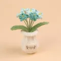 Detailopname van gehaakte bloemen in een witte gebreide pot met HandMade-label - Vergeet-mij-nietje Witte Vaas - Gradiënt Blauw