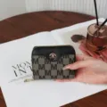 Elegante Damen-Kompaktbrieftasche mit Reißverschluss, M-Muster und schwarzem Lederbesatz - Schwarz