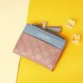 Close-up of women's short color-block wallet with quilted pattern and tassel heart charm - Deep Pink
