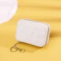 Nahaufnahme einer hochwertigen weißen gesteppten Mini-Kosmetiktasche mit goldenem Haken - Weiß