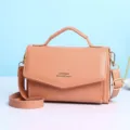 Elegante perzikkleurige dames crossbody tas met handvat en gouden metalen details - Roze