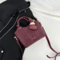 Borsa a secchiello in PU bordeaux con texture pelle di serpente e tracolla regolabile - Rosso