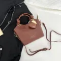 Elegante borsa a secchiello marrone motivo coccodrillo con ciondolo a cuore e tracolla - Marrone