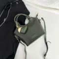 Elegante borsa a secchiello verde scuro con motivo a coccodrillo e ciondolo a cuore - Verde