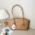 Minimalist brown PU leather underarm tote bag with cute white fuzzy monster keychain - Apricot