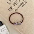 Close-up of a durable brown high-elastic hair tie with an elegant lavender bow charm detail - Bowknot Style / Dreamy Purple