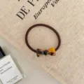 Detailed view of a brown elastic hair tie with a stylish tortoiseshell pattern bow decoration - Bowknot Style / Dark Leopard Print