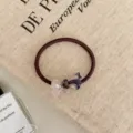 Close-up of a brown elastic hair tie with a stylish marbled purple resin bow charm detail - Ribbon Style / Dreamy Purple
