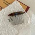 Macro view of tortoise shell acetate hair comb with metallic teeth and gold engraving - Blue Tortoise (E082) / Lake Blue Brown