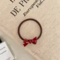 Close-up of the red bow detail on a durable high elasticity hair tie for women - Ribbon Style / Burgundy