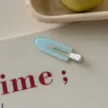 Close-up of a light blue glitter hair clip with white heart patterns and Fancy text - Light Blue Heart Polka Dot