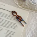 Detailed view of a tortoiseshell acetate small fish-shaped hair fork on a book - Lake Blue Brown - Small
