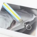 Detailansicht der gewebten Handgelenkschlaufe mit blau-gelbem geometrischem Muster. - Blauer Rand Silberner Verschluss