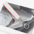 Detailansicht eines gewebten Armband-Schlüsselanhängers mit pfirsichblauem Muster - Rosa Rand Silberner Verschluss