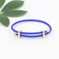 Primer plano de una pulsera de alambre trenzado azul con deslizador dorado ajustable - Azul Real
