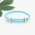 Detalle de la pulsera ajustable de cable trenzado azul con hebilla deslizante dorada - Azul Lago