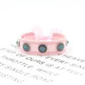 Detailaufnahme von rosa handgewebtem Armband mit Metallnieten und blauen Steinen - Stil 2